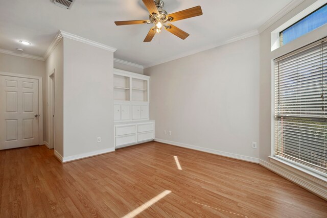 spare room featuring baseboards, light wood-style flooring, and crown molding