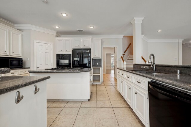 kitchen featuring light tile patterned floors, decorative columns, a sink, decorative backsplash, and black appliances