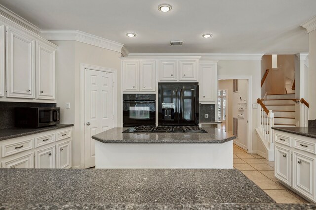 kitchen featuring tasteful backsplash, visible vents, crown molding, light tile patterned flooring, and black appliances