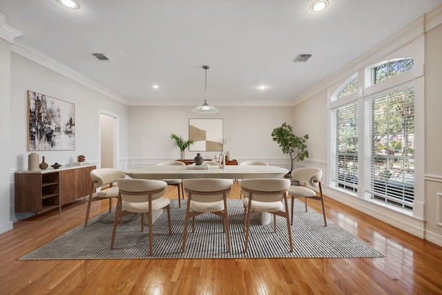 4207 Clearwater Ct, Missouri City, TX 77459 - dining area with visible vents, a wainscoted wall, light wood-style floors, and ornamental molding