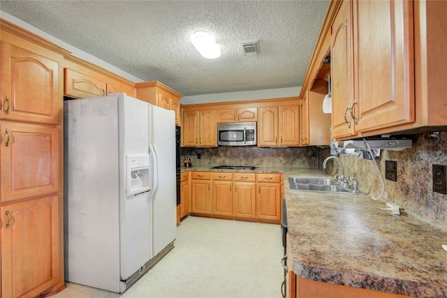 kitchen featuring light floors, a sink, visible vents, white fridge with ice dispenser, and stainless steel microwave