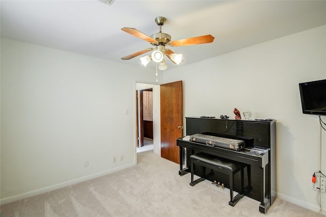 living area with light carpet, baseboards, and a ceiling fan