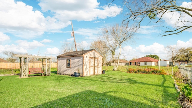 view of yard featuring a fenced backyard, a storage unit, and an outbuilding