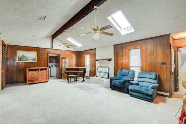 living area featuring wooden walls, visible vents, lofted ceiling with skylight, a textured ceiling, and carpet floors