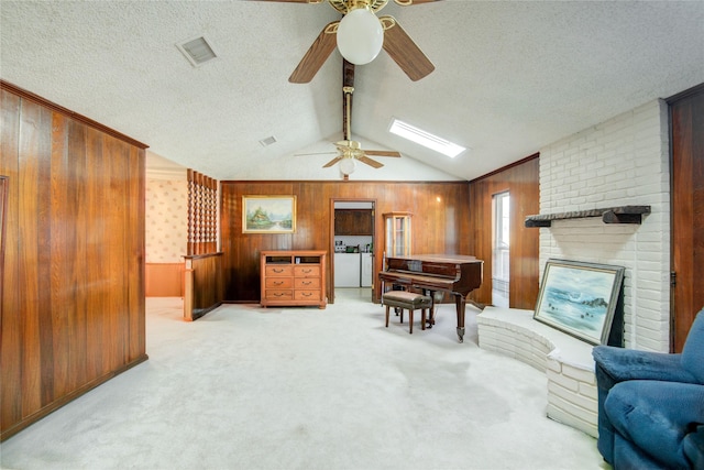 living area featuring lofted ceiling with beams, carpet floors, wood walls, visible vents, and washer and clothes dryer