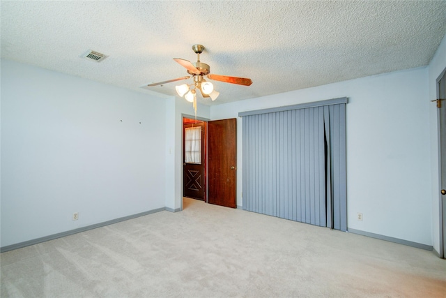 spare room with baseboards, visible vents, ceiling fan, a textured ceiling, and carpet flooring