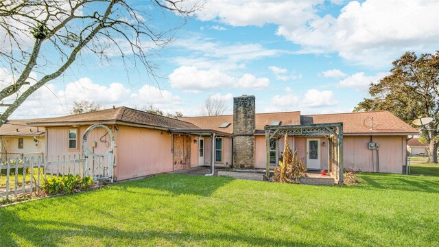 back of property featuring a yard, a chimney, fence, and a pergola