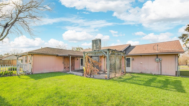 rear view of house with a lawn, a chimney, a gate, fence, and a pergola