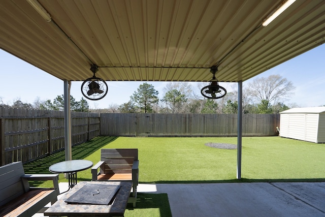 view of yard featuring a shed, an outdoor structure, and a fenced backyard