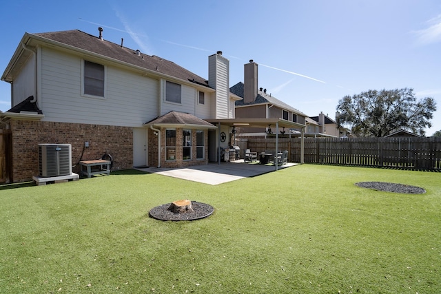 rear view of house featuring a patio area, fence, central AC, and brick siding