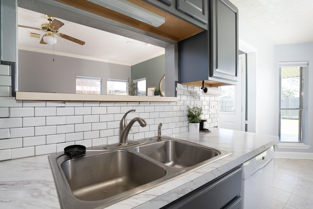 kitchen featuring ornamental molding, light countertops, a sink, and dishwasher