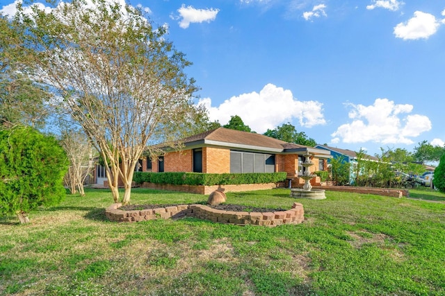 view of front facade with brick siding and a front lawn