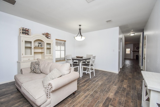 dining area featuring dark wood-type flooring, visible vents, and baseboards