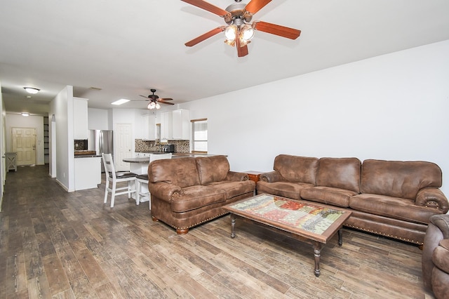 living area featuring dark wood-style flooring and a ceiling fan