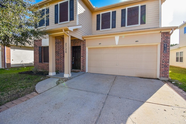 traditional home featuring a garage, concrete driveway, and brick siding