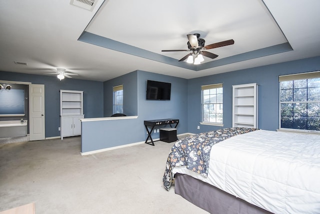 bedroom featuring carpet floors, a tray ceiling, visible vents, and baseboards