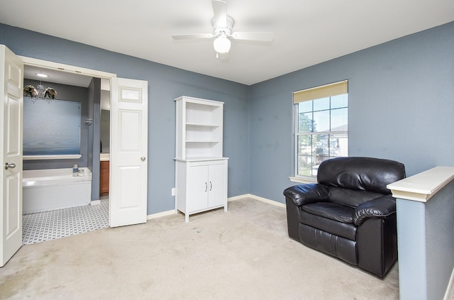 sitting room with a ceiling fan, light colored carpet, and baseboards