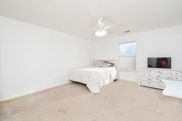 carpeted bedroom featuring a ceiling fan, visible vents, and baseboards