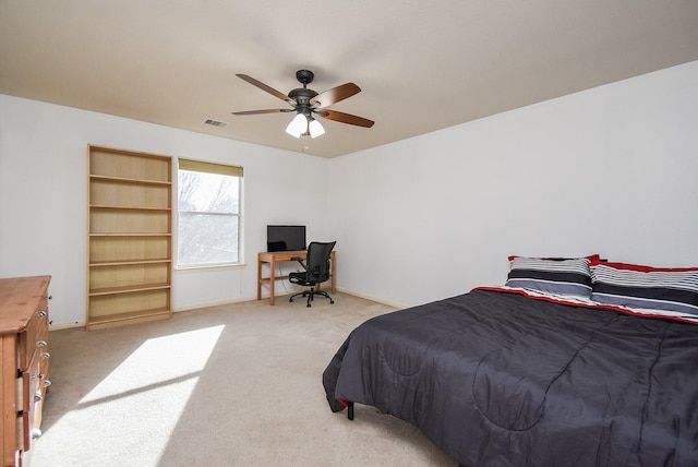 bedroom with a ceiling fan, light carpet, visible vents, and baseboards