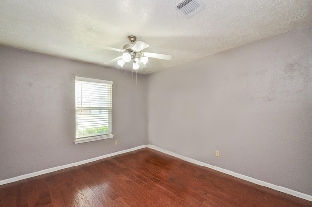 unfurnished room with visible vents, baseboards, dark wood-style flooring, and ceiling fan