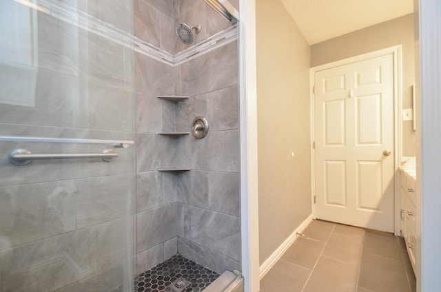 bathroom featuring tile patterned floors, baseboards, and a stall shower