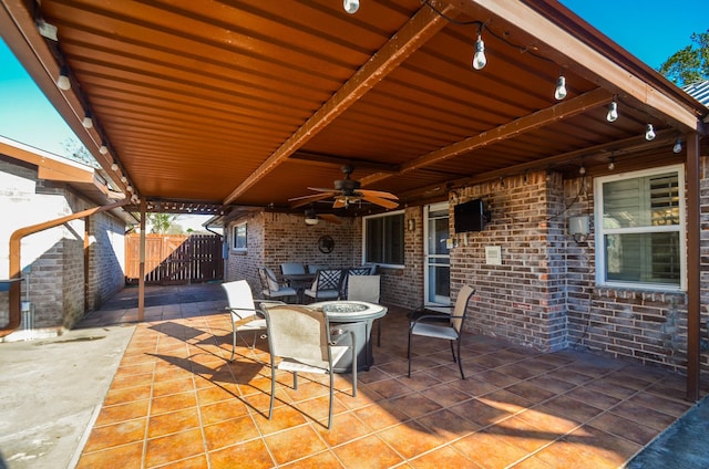 view of patio with fence, a ceiling fan, and an outdoor fire pit