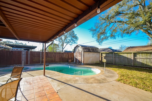 view of pool with a patio area, a fenced in pool, a storage shed, and a fenced backyard