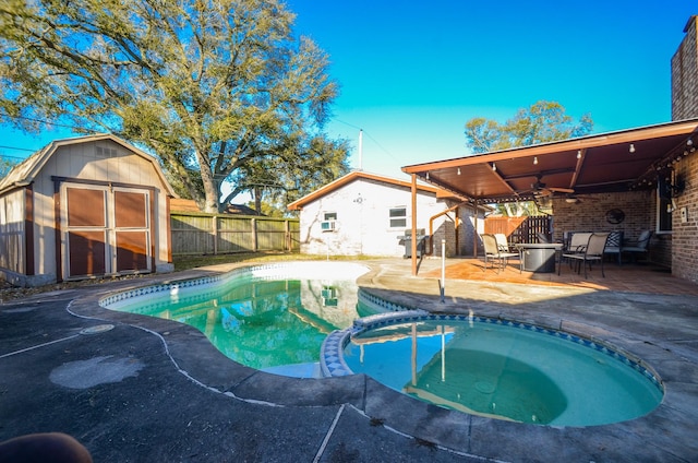 view of pool with ceiling fan, a fenced backyard, an outbuilding, area for grilling, and a patio