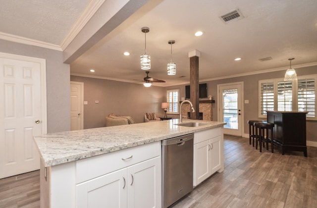 kitchen featuring a sink, visible vents, stainless steel dishwasher, and light wood finished floors