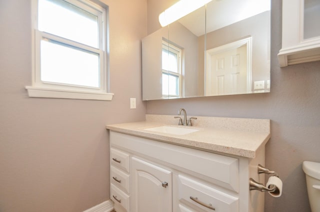 bathroom with baseboards, toilet, and vanity