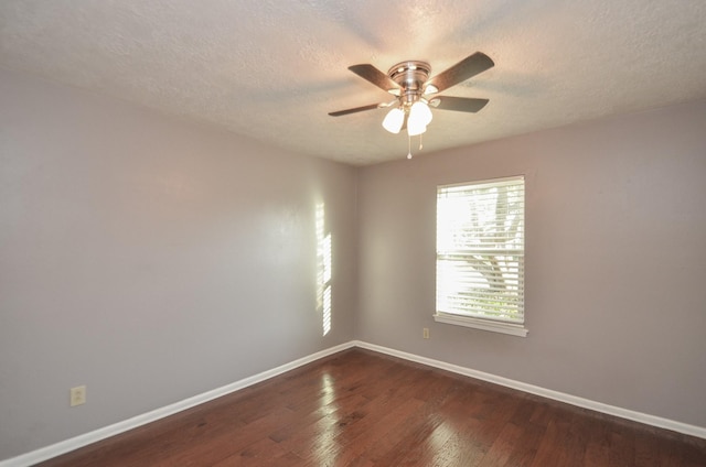 spare room with dark wood finished floors, ceiling fan, baseboards, and a textured ceiling