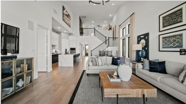 409 Silver Moon Way, Katy, TX 77493 - living area with a high ceiling, stairway, light wood-style floors, and recessed lighting