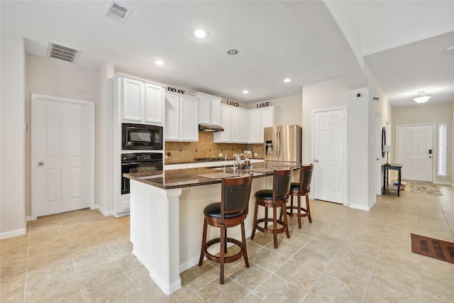 kitchen featuring black appliances, tasteful backsplash, visible vents, and white cabinets