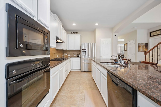 kitchen featuring black appliances, light tile patterned floors, dark stone counters, and a sink