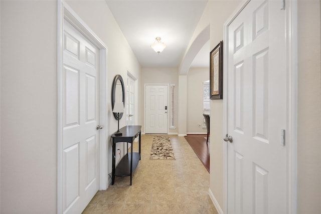 entryway featuring baseboards and arched walkways