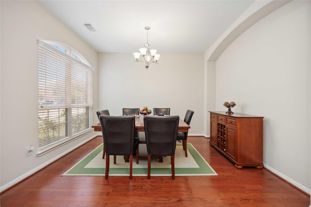 dining room with an inviting chandelier, visible vents, baseboards, and wood finished floors