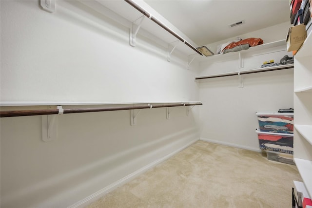 spacious closet with visible vents and light colored carpet