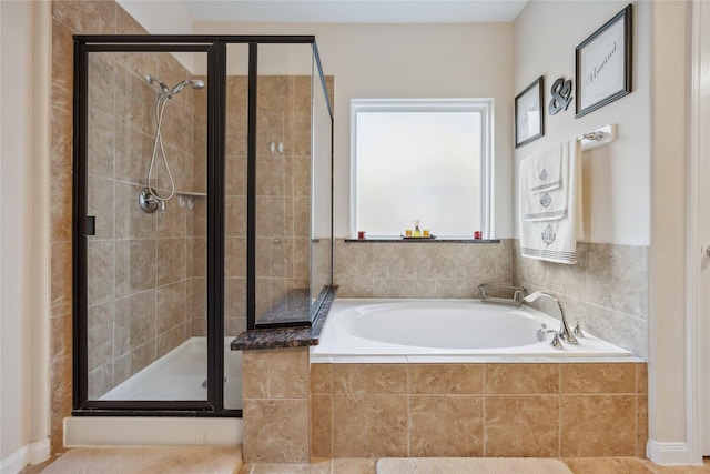 bathroom featuring a stall shower and a garden tub