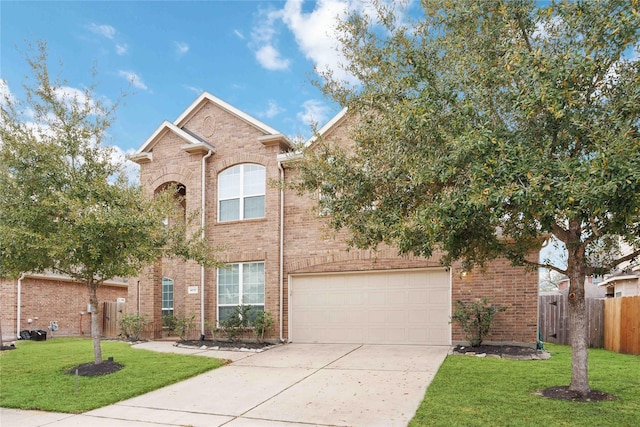 traditional home featuring a front lawn, concrete driveway, fence, and a garage