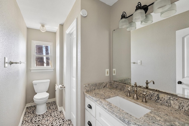 bathroom with tile patterned flooring, toilet, vanity, and baseboards