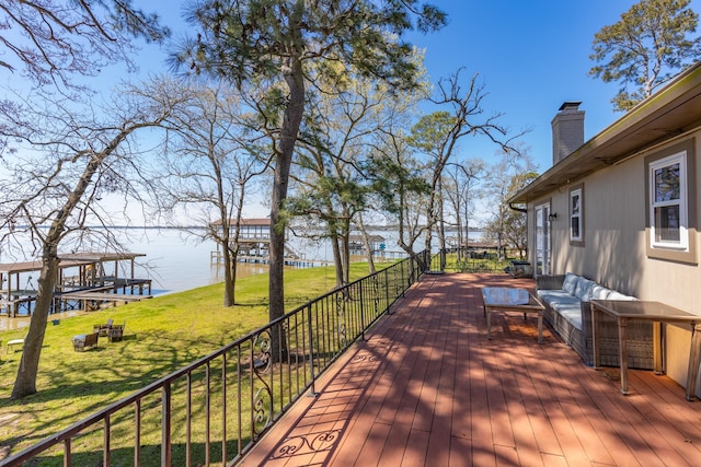 deck with a yard and a water view