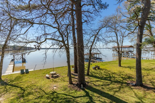 view of yard featuring a water view and a dock