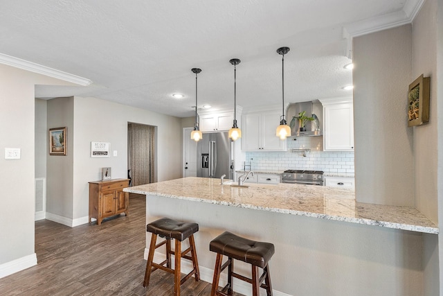 kitchen with premium appliances, white cabinetry, a peninsula, decorative backsplash, and dark wood-style flooring