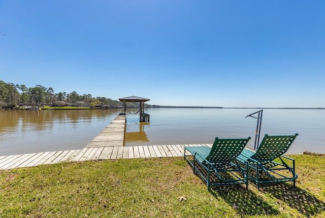 dock area with a lawn and a water view