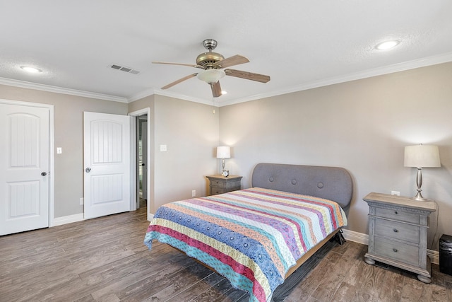 bedroom featuring visible vents, crown molding, and wood finished floors