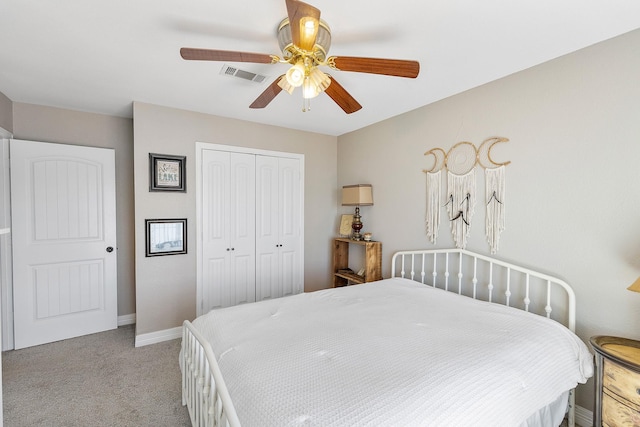 carpeted bedroom with visible vents, baseboards, a closet, and a ceiling fan