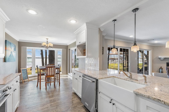 kitchen featuring tasteful backsplash, ornamental molding, stainless steel appliances, wood finished floors, and white cabinetry