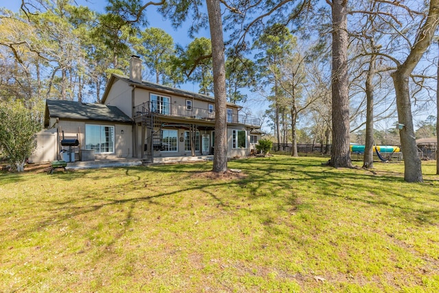 back of property featuring a yard, a chimney, a patio, and fence