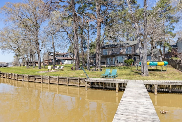 view of dock featuring a lawn and a water view