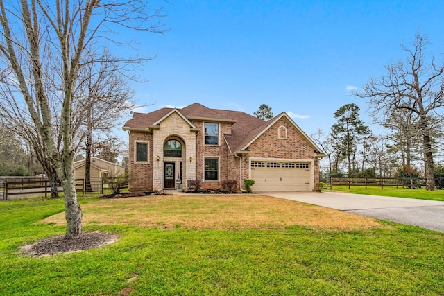 traditional home with concrete driveway, an attached garage, fence, a front yard, and brick siding